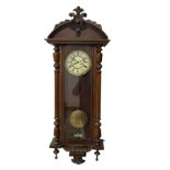 A late 19th century German Wall clock in a mahogany case with a carved semi-circular pediment