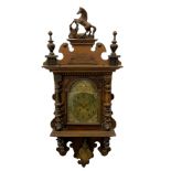 A compact early 20th century German wall clock c1910 in an oak case with applied carvings and decora