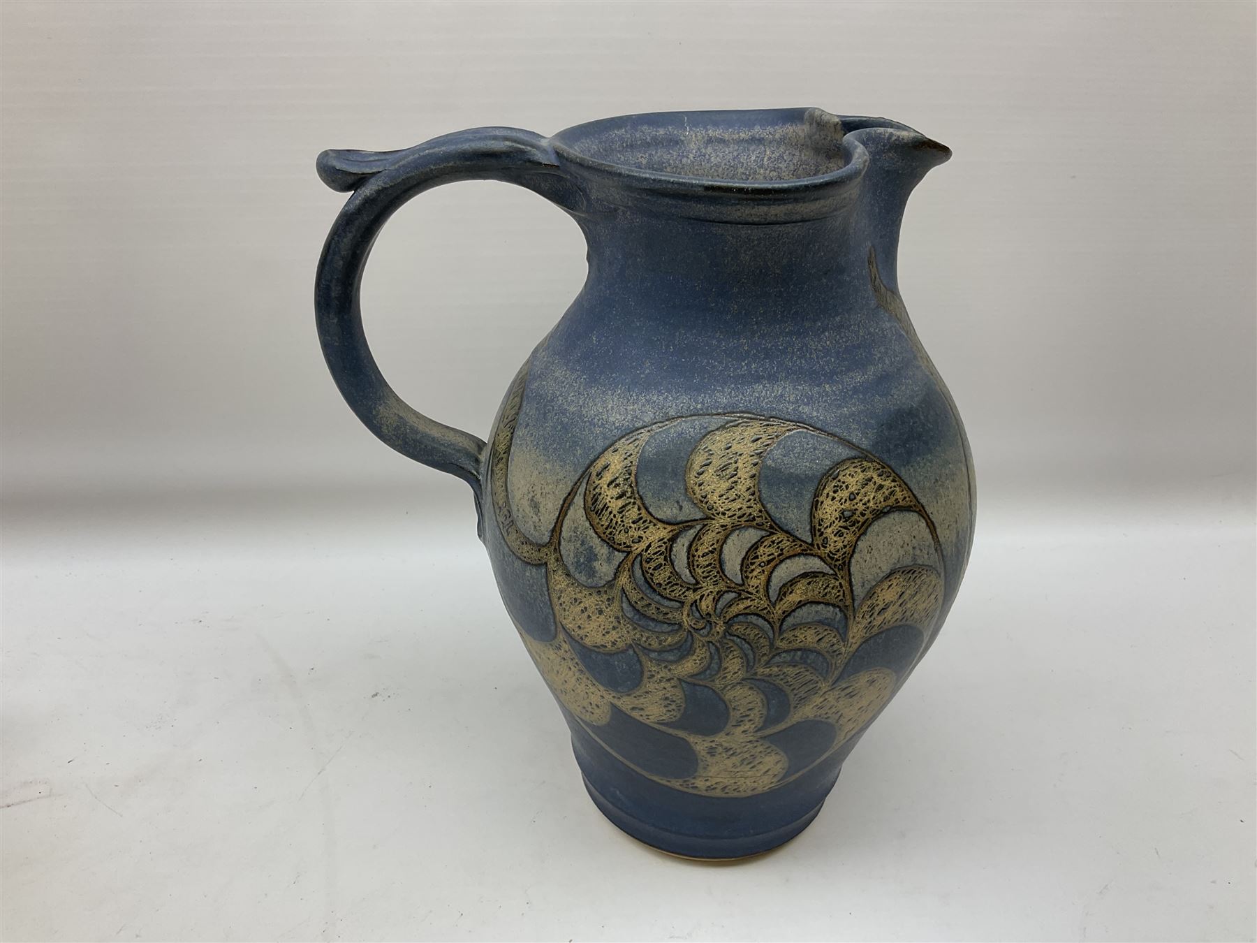 Group of studio pottery to include a large jug decorated with stylised ammonites upon a blue ground - Image 9 of 11