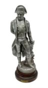 Early 20th century polished spelter figure of 'Napoleon' in a standing pose beside a rock on simulat