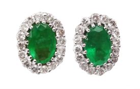 Pair of 18ct white gold oval emerald and round brilliant cut diamond stud earrings