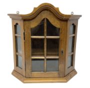 Glazed oak wall cabinet with arched top and projecting cornice