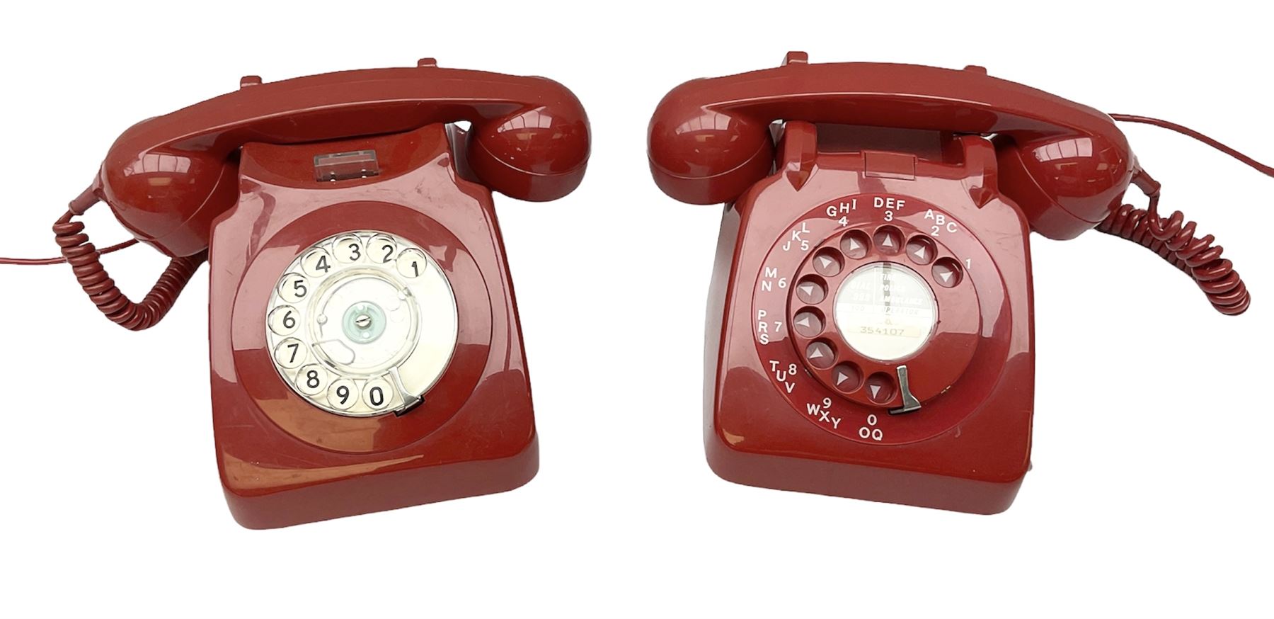 Two mid 19th century red telephones with rotary dials