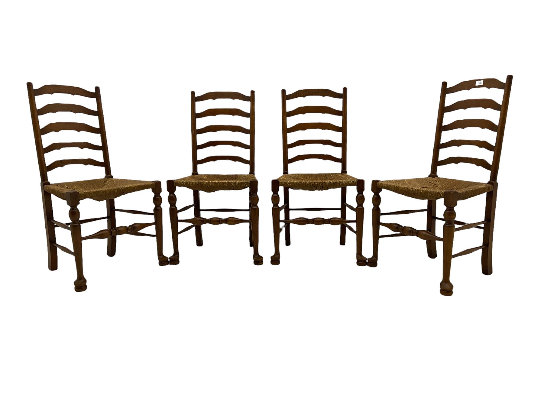 Four oak ladder back chairs with rush seats