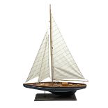 Wooden built model yacht with linen sails and mounted on wooden base