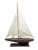 Wooden built model yacht with linen sails and mounted on wooden base