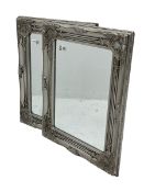 Pair bevelled edge wall mirrors in swept silvered frames decorated with ornate cartouches