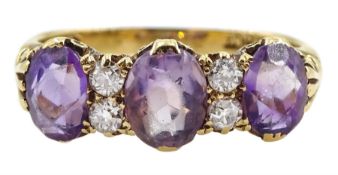 Early 20th century gold three stone oval amethyst and four stone old cut diamond ring with scroll de