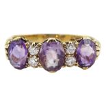 Early 20th century gold three stone oval amethyst and four stone old cut diamond ring with scroll de