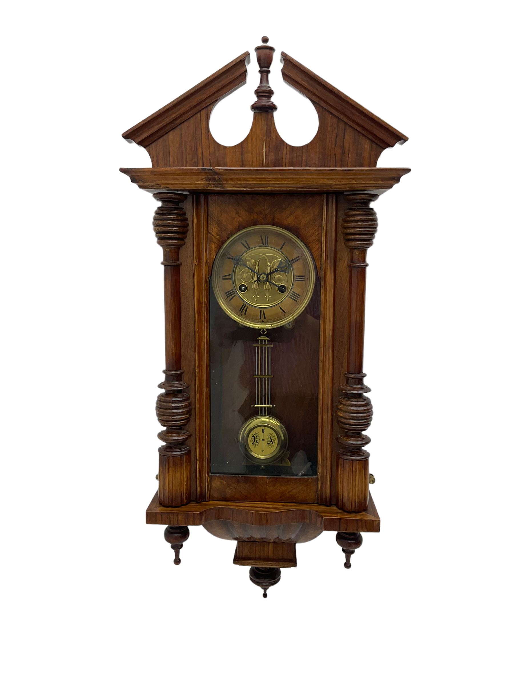 German early 20th century wall clock in a mahogany case with an architectural pediment and turned fi