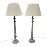 Pair of composite grey washed table lamps with a slender column upon a circular foot with natural li