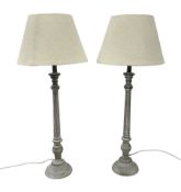 Pair of composite grey washed table lamps with a slender column upon a circular foot with natural li