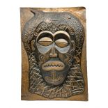Copper panel embossed with a design of an African mask