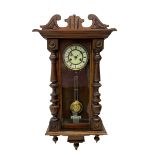 Small Spring driven German wall clock in a mahogany case with turned columns and pendants