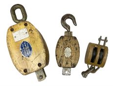 Three ship pulleys comprising wooden block double with swivel eye marked 'wooden block 240mm bduble