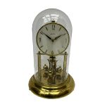 A mid-20th century �Bentima� 400-day anniversary torsion clock with a 7� circular brass base and une