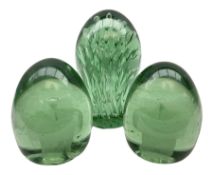 Pair of Victorian green glass dump paperweights with interior flower decoration