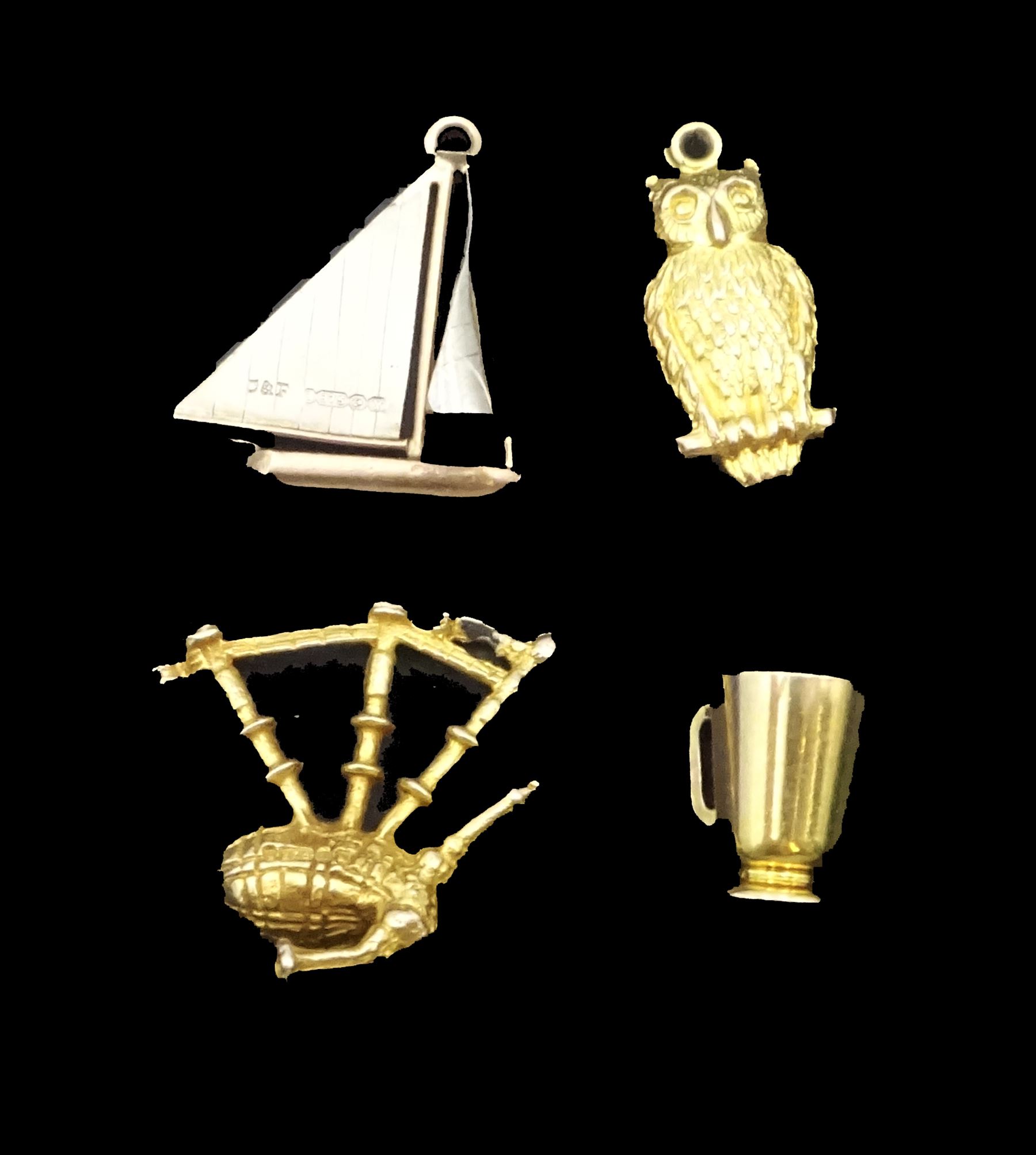 Four 9ct gold charms including sailing boat