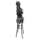 Art Deco style bronze figure of a lady seated on a stool applying lipstick