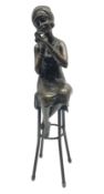 Art Deco style bronze figure of a lady seated on a stool applying lipstick