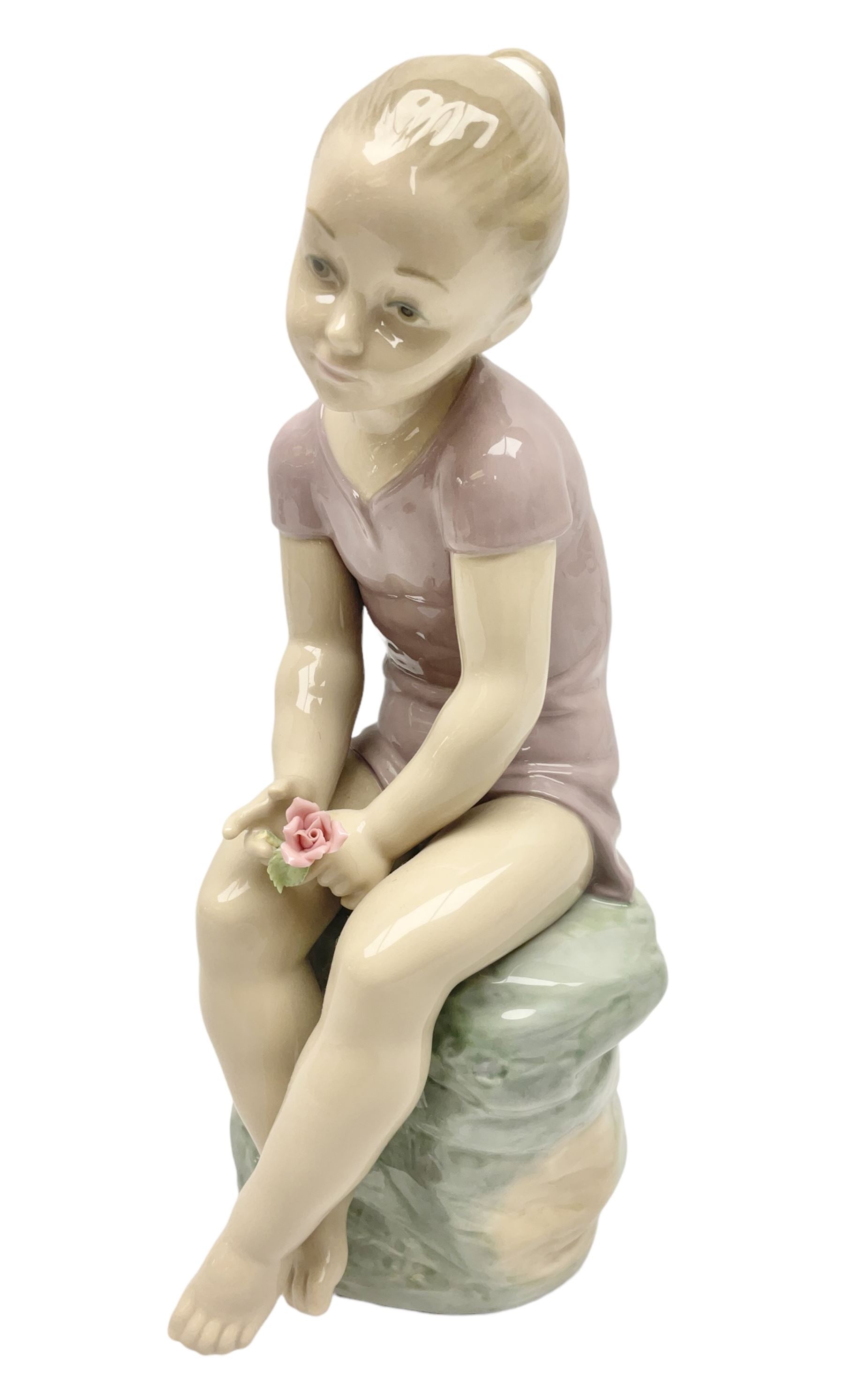 Large Nao figure modelled as a young girl seated upon a rock holding a rose