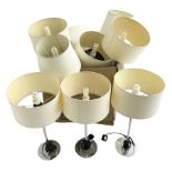 Set of nine chrome table lamps with cream shades