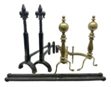 Pair of wrought iron fire dogs with fleur-de-lis finials upon twisted stems