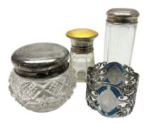 Three glass dressing table jars with silver covers