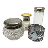 Three glass dressing table jars with silver covers