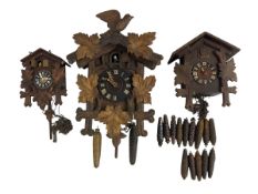 Three 20th century cuckoo clocks and a selection of weights.