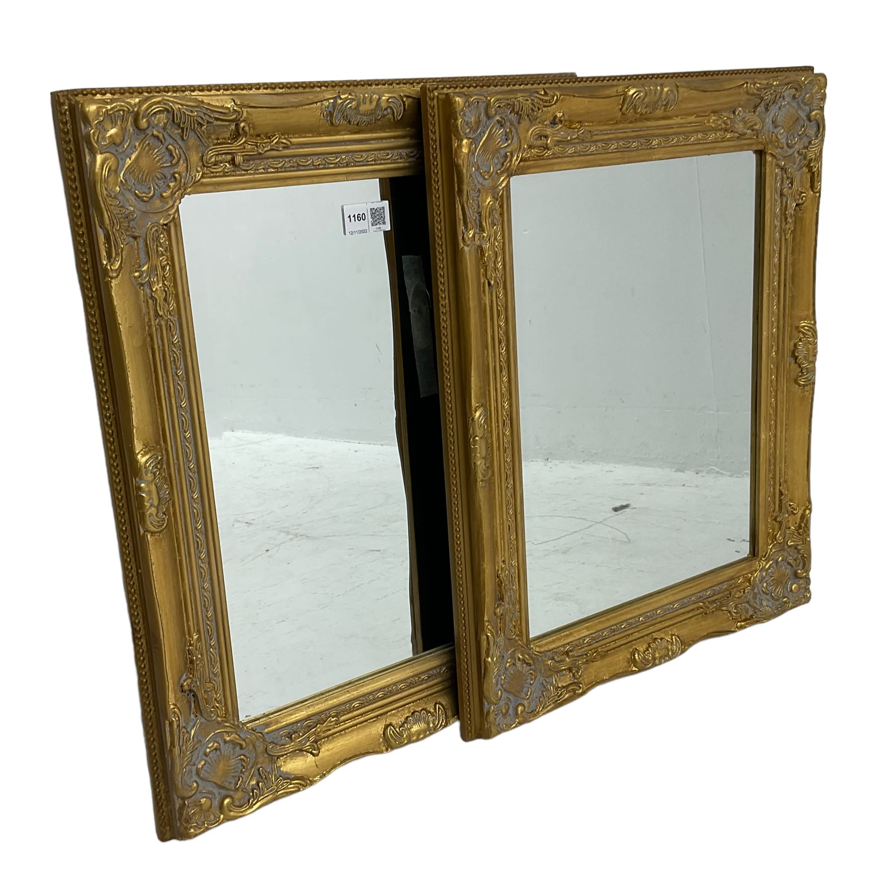 Pair bevelled edge wall mirrors in swept gilt frames decorated with ornate cartouches