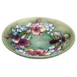 Moorcroft bowl decorated in Orchid pattern on a green ground