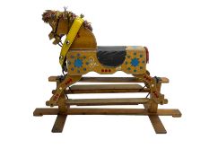 Painted rocking horse on polished pine trestle base