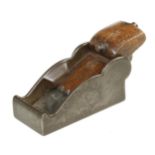 A steel chariot plane 3 1/2" x 1 3/4" with wedge held behind two steel lugs. Tiny crack to mouth G+