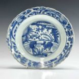 A Chinese blue and white porcelain plate, late Ming Dynasty, with a barbed rim, the centre painted