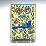 A Persian pottery tile, 19th century, decorated with a bird amongst flowers, 16.5 x 11cm.