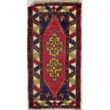 A North West Persian rug, of Caucasian design, the madder field with two saffron medallions