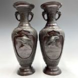 A pair of Japanese bronze twin-handled vases, Meiji period, seal mark, relief decorated with