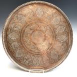 An Islamic copper tray, 19th century, signed, decorated with numerous cartouches including figures