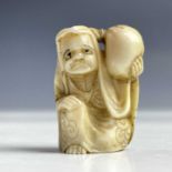 A Japanese ivory netsuke of a man holding a bag on his shoulder, Meiji period, height 3.5cm, width