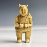 A Japanese ivory netsuke of a standing figure holding a palm leaf, late 18th/early 19th century,