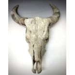 A water buffalo skull with horns, carved with a figure, birds, horses and sea horses, height 74cm,