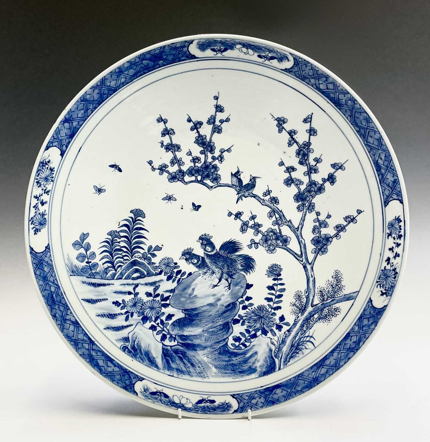 A Chinese blue and white porcelain charger, 19th century, with birds perched on a blossoming tree