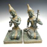 Two Thai gilt and painted bronze figures of deities, 20th century, each kneeling playing a lute