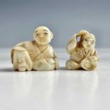 Two small Japanese ivory netsukes of seated figures, Meiji period, each signed, heights 2cm.