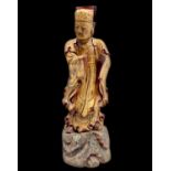 A large Chinese gilt wood and red lacquer figure of a scholar, late 19th century, standing on a