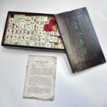 A Chinese mahjong set, early-mid 20th century, with 149 bamboo and bone tiles, the stained wood