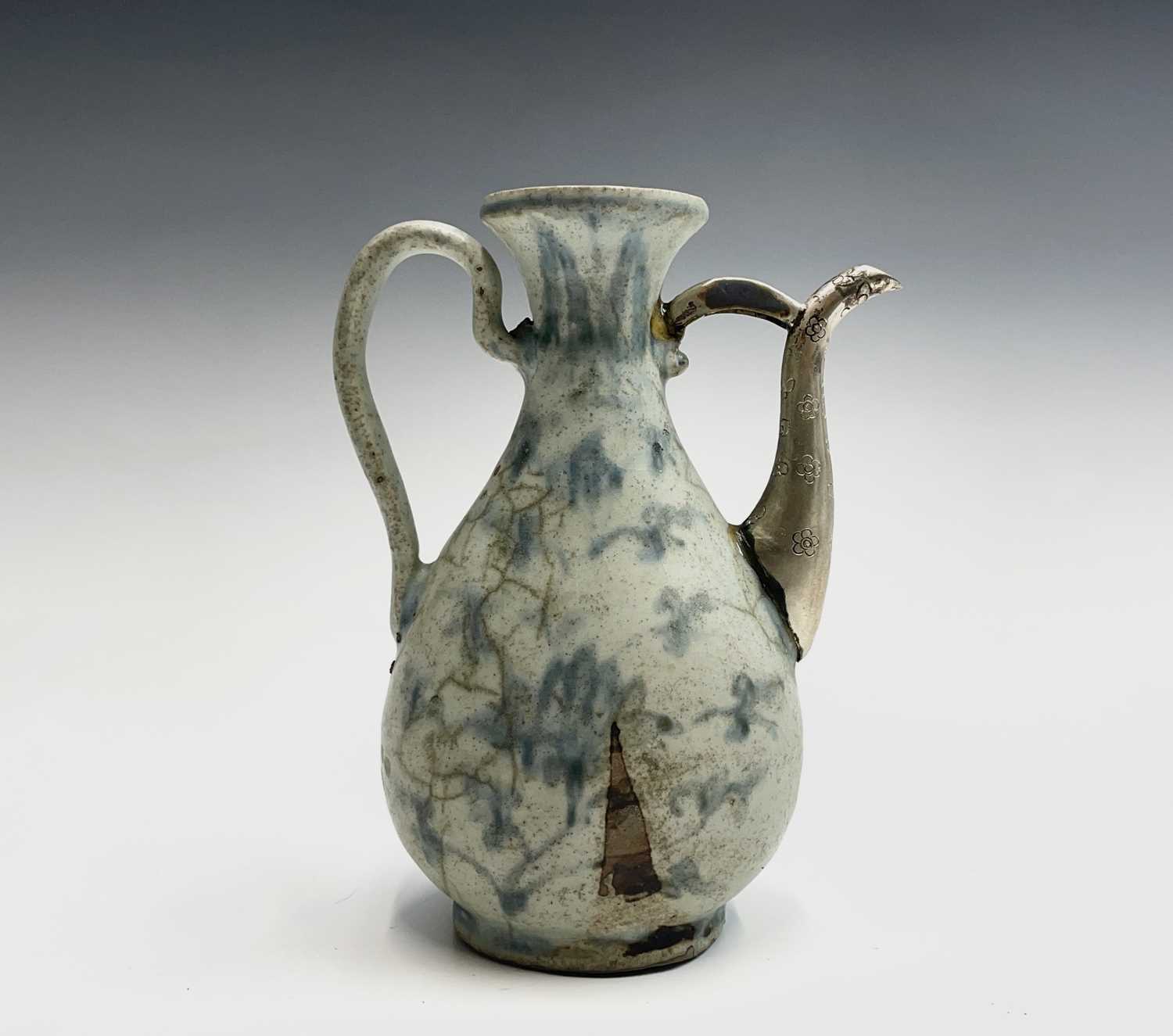 A Chinese blue and white ewer, Ming Dynasty, with white metal spout, height 18.5cm, width 14cm.