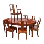 A Chinese reproduction hardwood extending dining table and set of six chairs, including two