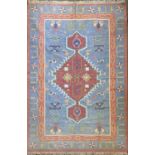 A Persian kelim rug, 20th century, the blue ground with a central red medallion, with guls, within a